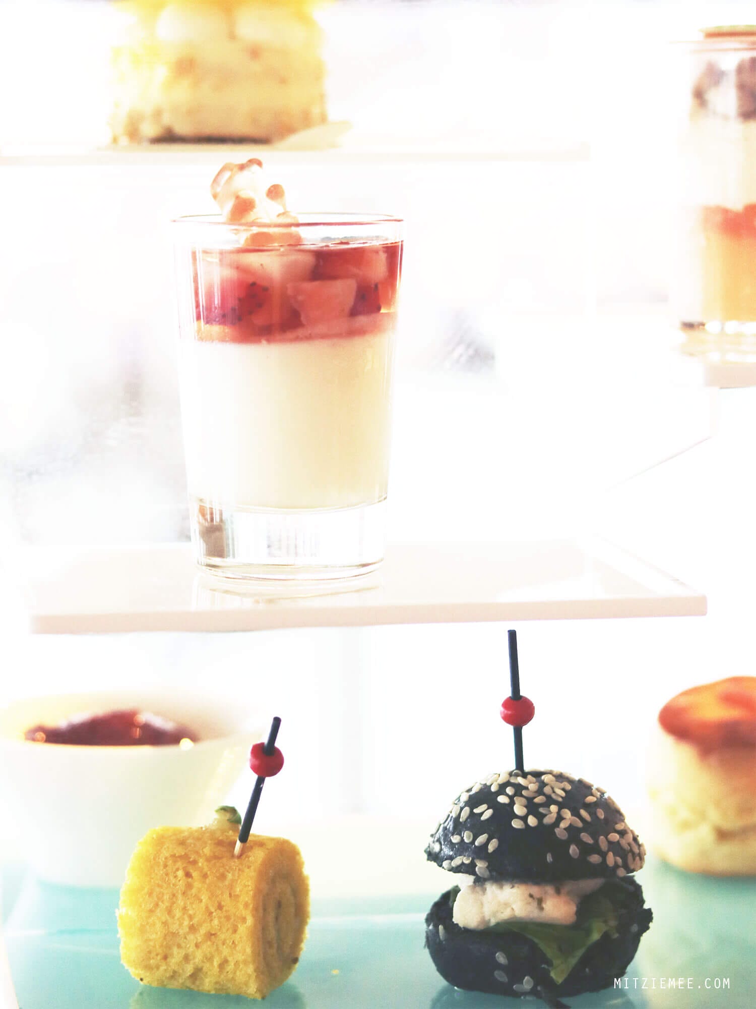  On my last day in Hong Kong it was pouring down. I had to check out from the hotel at noon, but my flight was not until the evening, and my original plan to go for a walk along the water did not seem very attractive. Instead I called The Ritz-Carlton in Hong Kong and made a reservation for the afternoon tea at Café 103. My table was far from the floor-to-ceiling windows, so even though I was on the 103rd floor, I did not have much of a view. Instead they provided me with different kinds of magazine, so I wouldn’t get bored during my afternoon tea for one. Except for the view (or the lack of it), it was a really nice afternoon tea. First, I was asked to pick the tea I wanted, and it was more difficult than it sounds, because there were so many different kinds to choose among. After consulting the waiter, who turned out to be very well-versed in teas, I finally decided on the Sakura Sakura tea, which was a green tea with cherry blossoms and a mild and flowery flavor. The Ritz-Carlton in Hong Kong are known for collaborations with chefs and different gourmet brands for the afternoon tea, and when I was there, the menu was made in collaboration with luxury candy store Sugarfina, which are particularly known for boozy gummy bears. One of the desserts I had was a champagne cream with strawberry topped with a champagne-infused gummy bear, and it was exquisite. I could have eaten a whole family of those bears:) It was a nice way to spend the afternoon but next time I go, I will try to get a table with a better view. I did a little online research, and it seems like The Lounge & Bar, which is on the 102nd floor and also serves afternoon tea, has more window tables available, so maybe they are a better choice. Otherwise, there is always Ozone, which is the beautiful bar on the 118th floor at the Ritz-Carlton. 